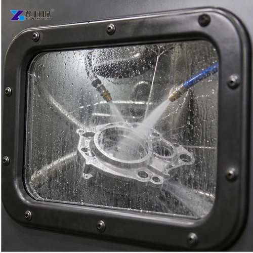 Wet slurry jets cleaning a machined housing through cabinet window