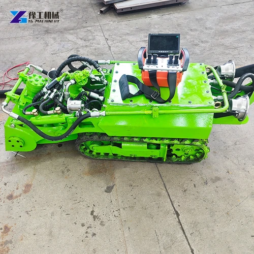 Green tracked dredging robot with operator control screen on a concrete floor