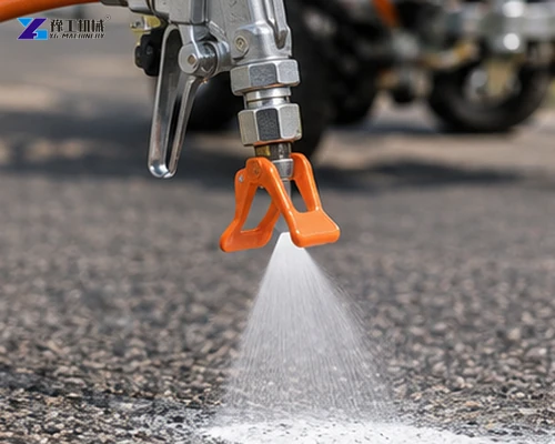 Road marking spray nozzle applying a white fan of paint to asphalt