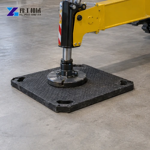 Close detail of outrigger and load-spreading mat on a concrete floor