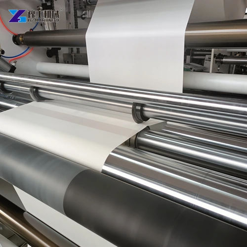 White paper web passing through the roller section before slitting