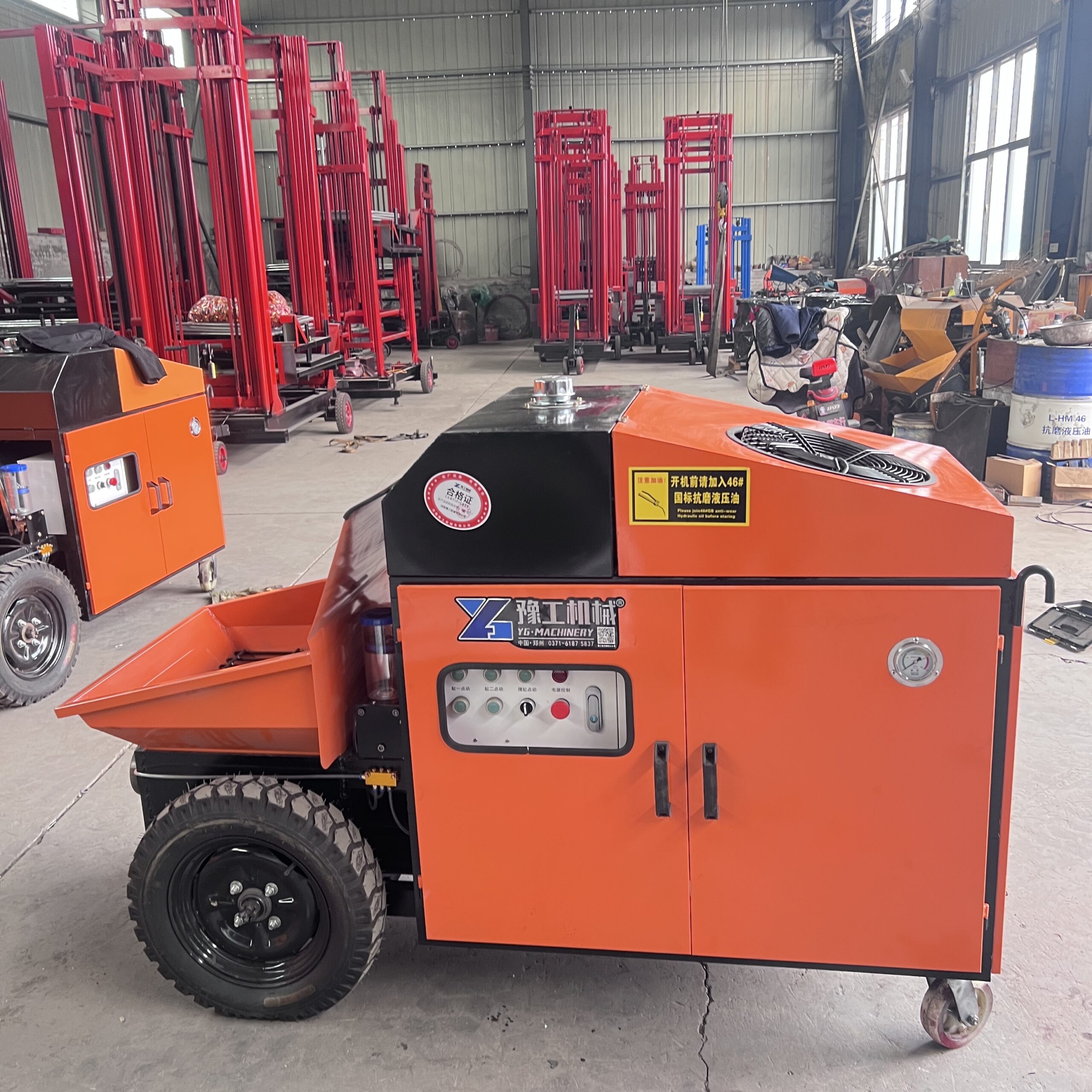 Compact yellow electric concrete pump with hopper and control cabinet