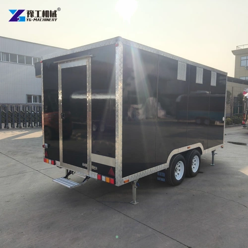 Rear quarter of a black twin-axle trailer parked in a factory yard