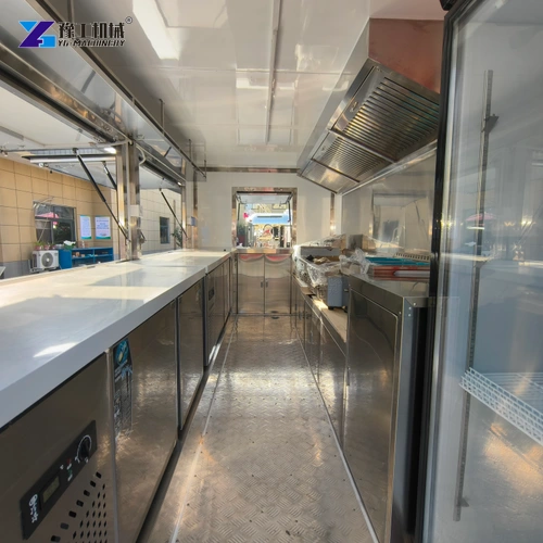 Stainless counters and refrigeration alongside the aisle of a real catering trailer