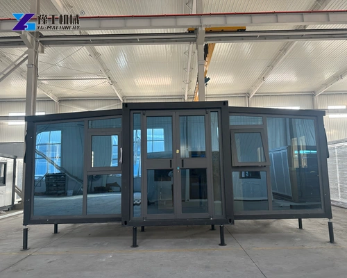 Glazed front entrance of an expandable house inside a factory