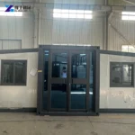 Expanded Prefab House With Central Glazed Entrance And White Wall Panels
