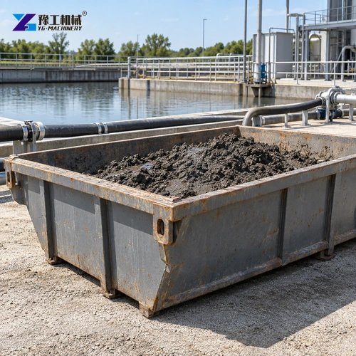 Contained skip holding damp removed sediment beside neatly arranged hoses