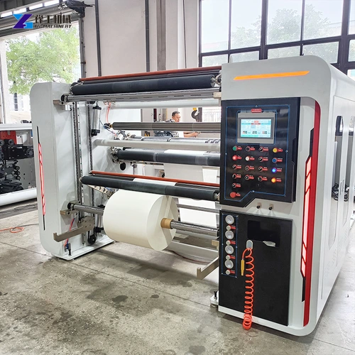 Slitter rewinder positioned on a workshop floor beside material equipment
